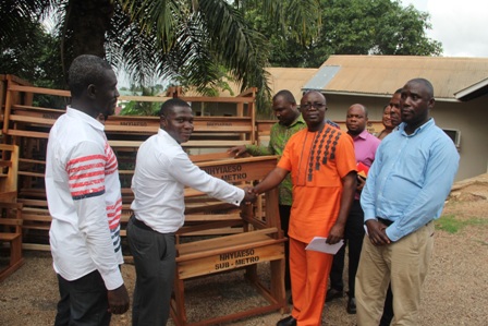 Hon. Osei Assibey Antwi (right ) shaking hands with Mr. Addae Louis who received the desk on behalf of the schools.
